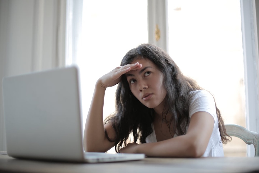 young woman confused using laptop